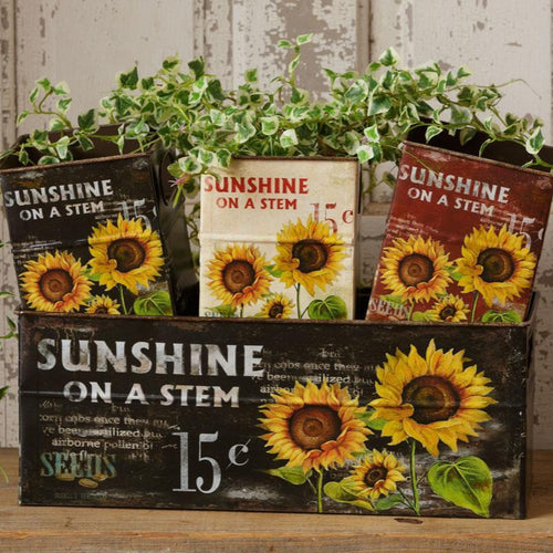 Decorative boxes with sunflower designs and 'Sunshine on a Stem' text on a wooden surface.
