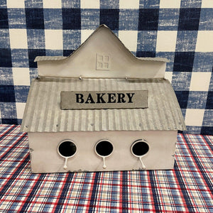 Metal "Bakery" Birdhouse in cream with sign and perches.