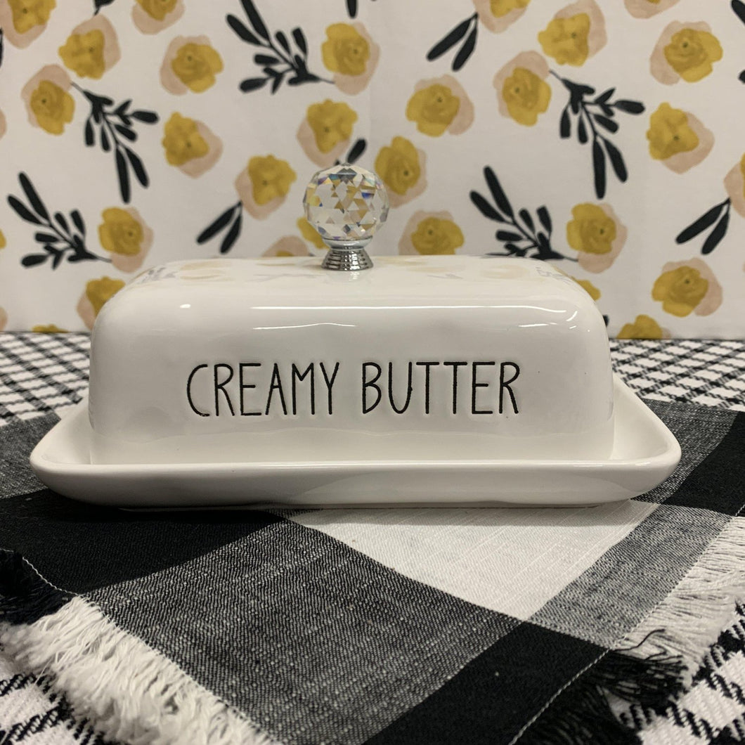 Creamy white ceramic butter keeper with black print and crystal knob