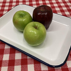 Enamelware serving tray with blue trim displayed with apples