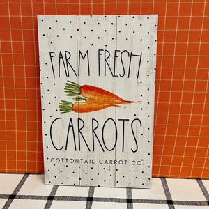 Farm Fresh Carrots wood sign with polka dot background and bright orange carrots.
