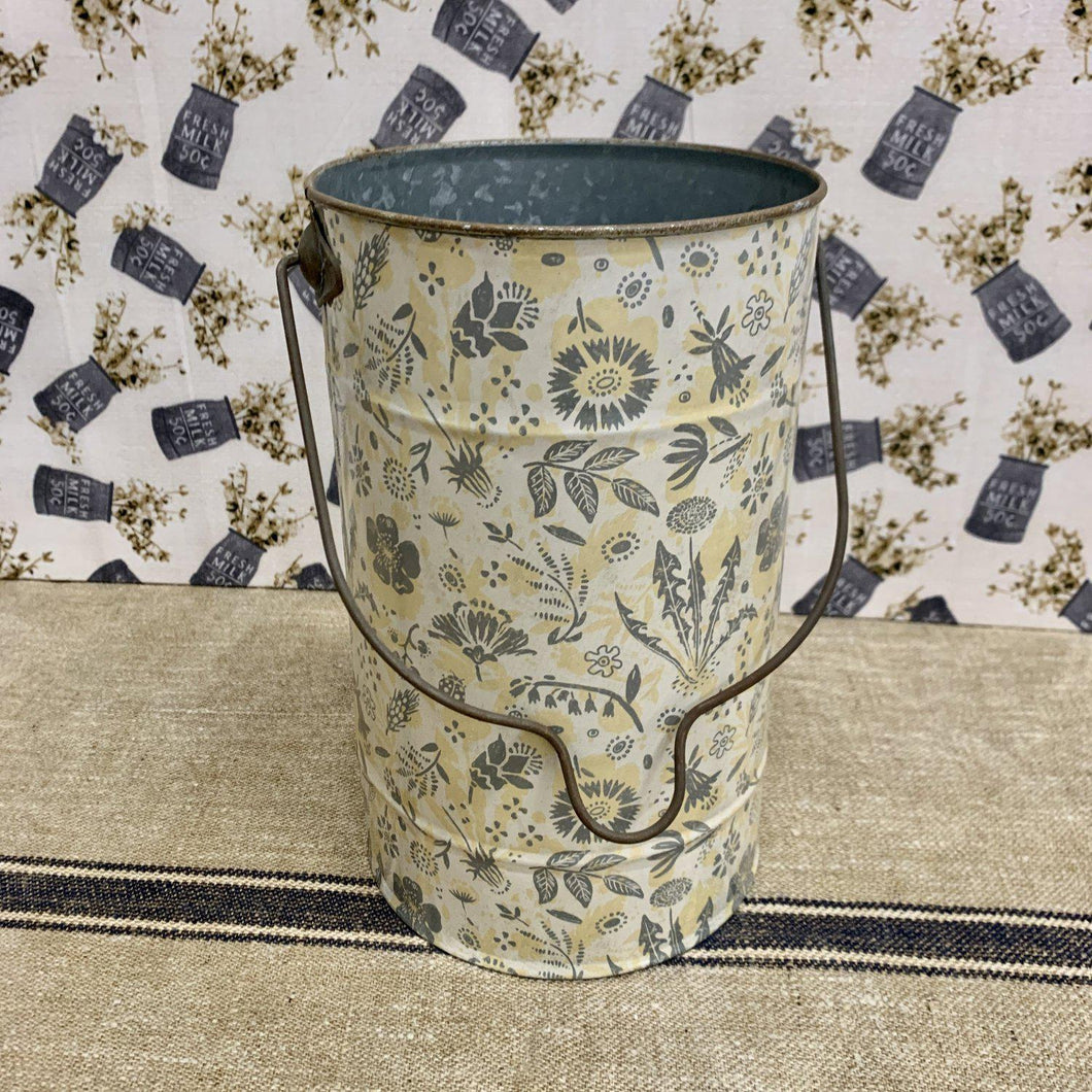 Farmhouse metal bucket with floral design in grays and yelloe