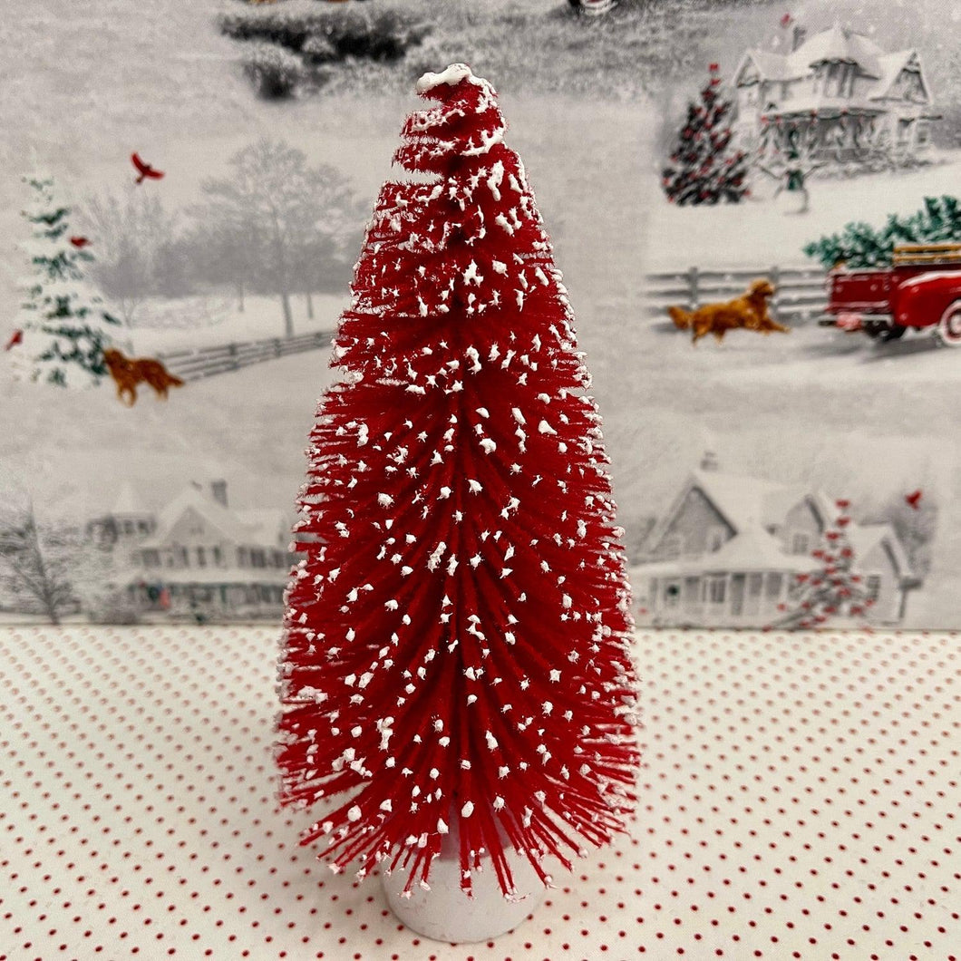 Large Red flocked Christmas Tree with snow tipped branches.