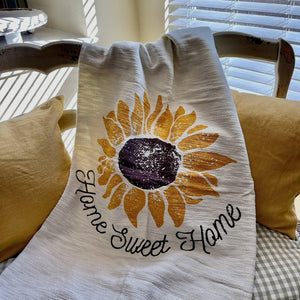 Lightweight Throw with "Home Sweet Home" on woven background with fringe accent.