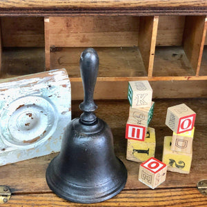 Black iron School Bell on desk with blocks