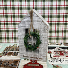 Load image into Gallery viewer, Wooden block holiday house with a seasonal message and small hanging wreath