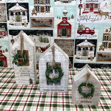 Load image into Gallery viewer, Wooden block holiday houses with seasonal messages and small hanging wreaths