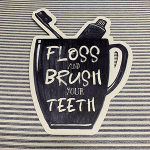 Black and white metal Floss & Brush sign
